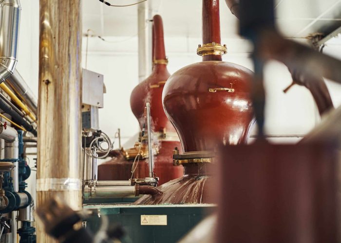 distillation-3 Copper pot stills inside the Rozelieures distillery, where heat and distillation equipment are used to transform fermented mash into French single malt whisky.