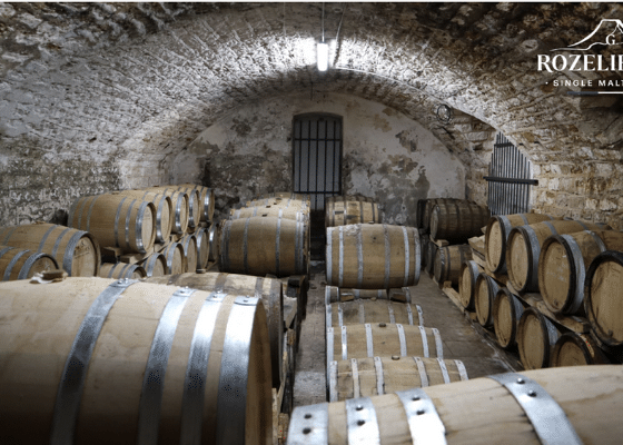 vieillissement-3 Oak casks aging whisky inside a historic stone cellar at Rozelieures, where underground conditions support the maturation of French single malt whisky.